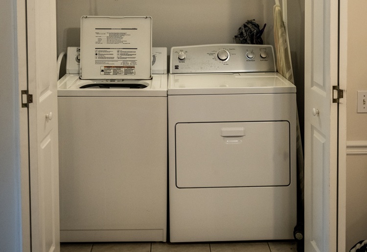 Kitchen area with washer dryer dishwasher and microwave
